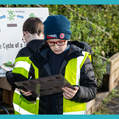 Student studying workbook outdoors - 400x400